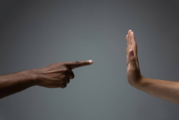 Rasová tolerance. Respektovat společenskou jednotu. Africké a kavkazské ruce gestikulující izolované na šedém pozadí studia - Fotografie, Obrázek