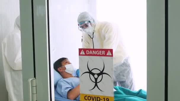 The doctor takes care a sick patient, coughing from coronavirus on hospital bed. sick man on a hospital bed. - Metraje, vídeo