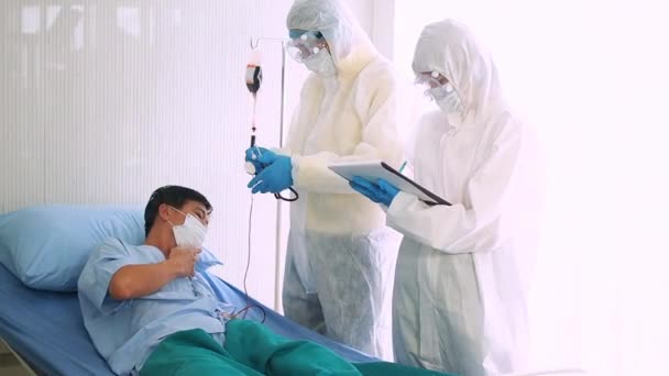 O médico cuida de um paciente doente, tossindo de coronavírus na cama do hospital. homem doente em uma cama de hospital
. - Filmagem, Vídeo