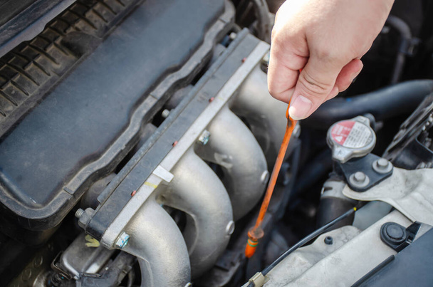 Człowiek sprawdza poziom oleju w silniku samochodowym, Sprawdź i utrzymania poziomu oleju w samochodzie ze sobą. - Zdjęcie, obraz