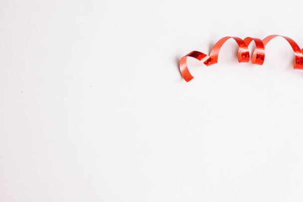 Red ribbon for gift wrapping. Decor for the holidays. Spiral of tape. - 写真・画像