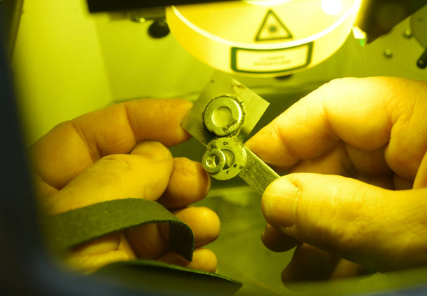 Mužské ruce držící kovové kusy v komoře laserového zařízení svařované metodou vysoce přesného laserového mikrosvařování, zblízka - Fotografie, Obrázek
