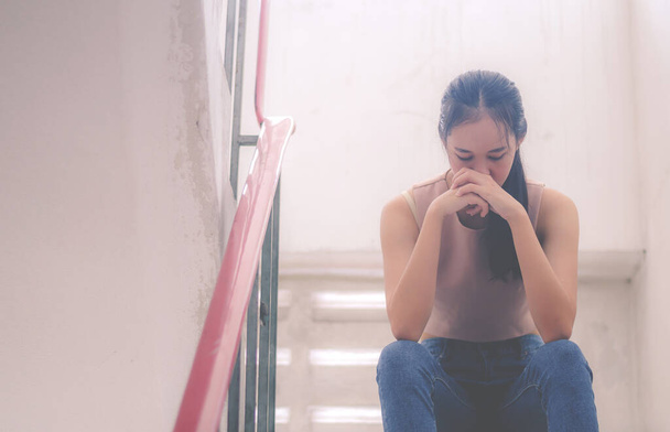 Nieszczęśliwy przygnębiony nastolatek z twarzą w rękach siedzi schody w starym mieszkaniu, Smutna dziewczyna, Płacz, koncepcja dramatu - Zdjęcie, obraz