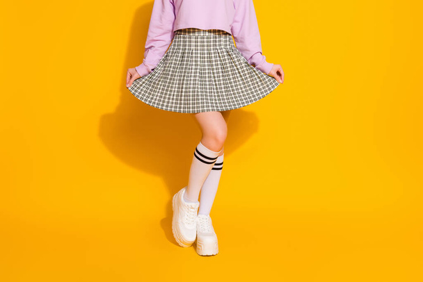 Cropped view of her she nice attractive fashionable slim fit feminine girl wearing checked skirt posing isolated on bright vivid shine vibrant yellow color background - Foto, imagen