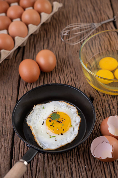 Huevos fritos en sartén y huevos crudos, alimentos ecológicos para una buena salud, ricos en proteínas
 - Foto, imagen
