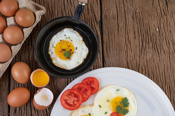 Huevos fritos en sartén y huevos crudos, alimentos ecológicos para una buena salud, ricos en proteínas
. - Foto, imagen