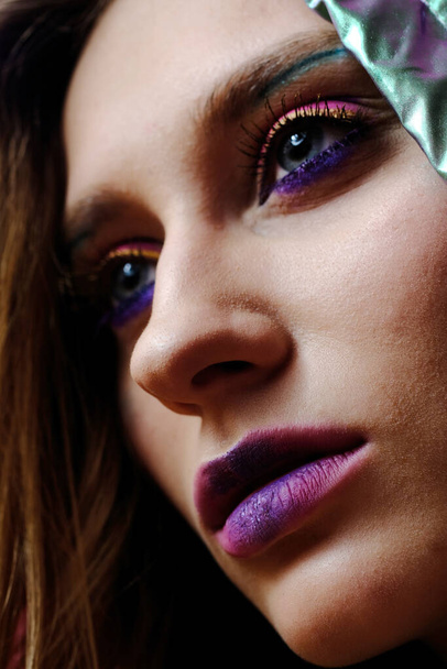 A close-up portrait of a beautiful girl of 20-25 years old with bright makeup and blue eyes. - Foto, imagen