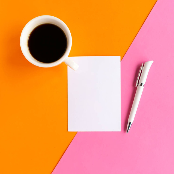 Kaffeetasse und weiße Mockup-Rohlinge auf geometrischem rosa und orangefarbenem Hintergrund, Draufsicht. Minimales Konzept - Foto, Bild