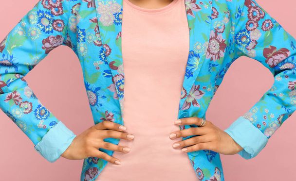 Detalle de moda de una chaqueta azul floral a medida en una esbelta joven de pie con la mano en las caderas en un primer plano en su entrepierna
 - Foto, imagen