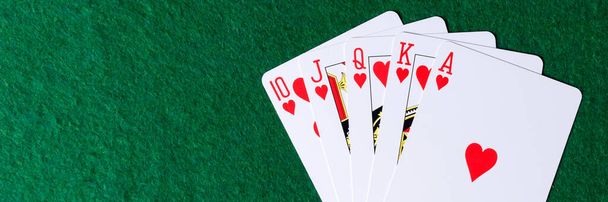 Obraz panoramiczny. Królewski kolor serc na zielonym tle. Zwycięskie ręce kart do gry w pokera - Zdjęcie, obraz