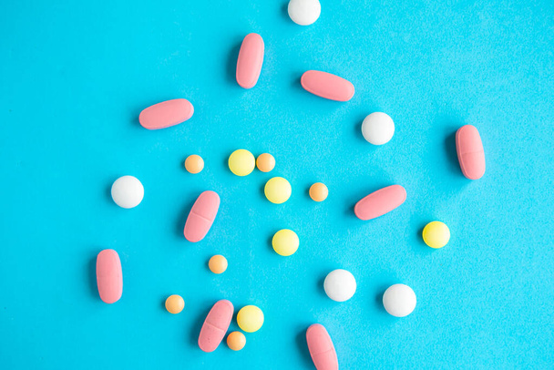 Медицинские таблетки на ярко-голубом фоне, концепция covid-19
 - Фото, изображение