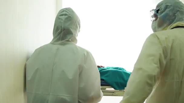 Lääkäri huolehtii sairaasta potilaasta, joka yskii sepelvaltimoviruksesta sairaalan sängyssä. sairas mies sairaalavuoteella. - Materiaali, video