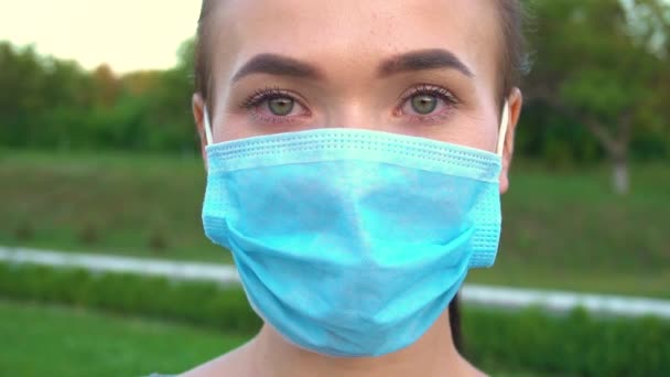 Woman in protective medical mask looking at camera. - Кадры, видео