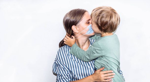young woman in a blue striped shirt in a medical mask with a baby in her arms. remedy for coronavirus, covid 19,  - Photo, Image