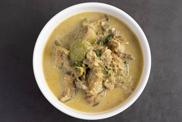 Chicken green curry in a white cup on the cement ground. - Φωτογραφία, εικόνα