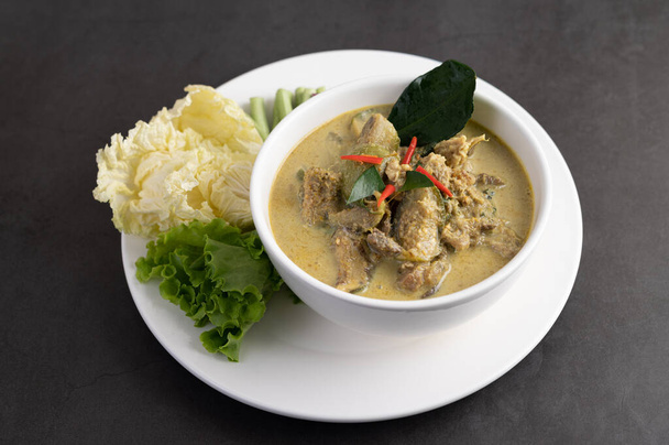 Chicken green curry in a white cup on the cement ground - Фото, изображение