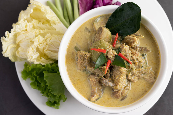 Chicken green curry in a white cup on the cement ground - Φωτογραφία, εικόνα