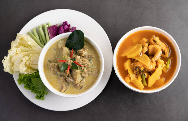 Chicken green curry in a white cup and Snakehead fish curry on the cement ground - Φωτογραφία, εικόνα