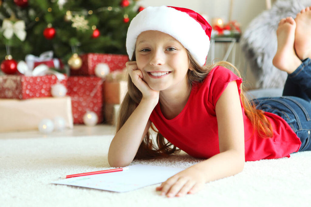 Little girl in Christmas interior writes a letter to Santa Claus - Foto, Bild