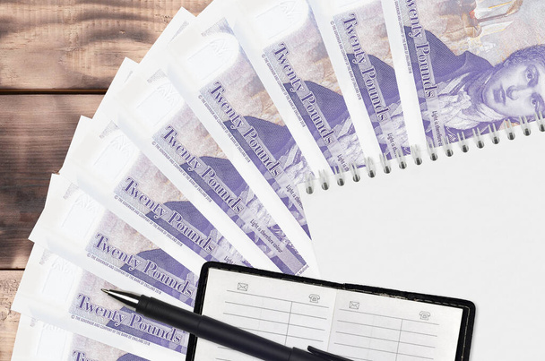 20 İngiliz poundu fatura, yelpaze ve siyah kalemli not defteri. Finansal planlama ve iş stratejisi kavramı. Muhasebe ve yatırım - Fotoğraf, Görsel