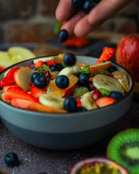 Añadir arándanos a la ensalada de frutas frescas
 - Foto, imagen