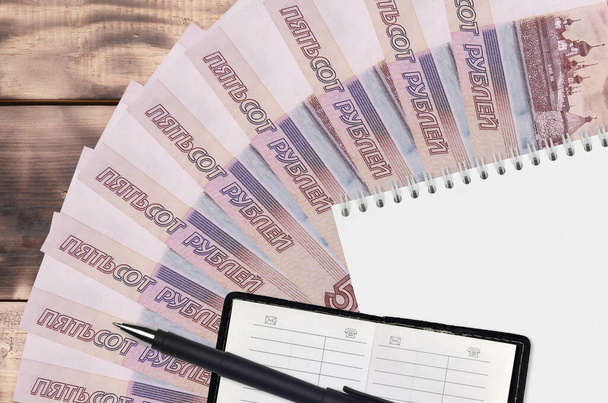 500 rublos russos contas ventilador e bloco de notas com livro de contato e caneta preta. Conceito de planejamento financeiro e estratégia de negócios. Contabilidade e investimento
 - Foto, Imagem