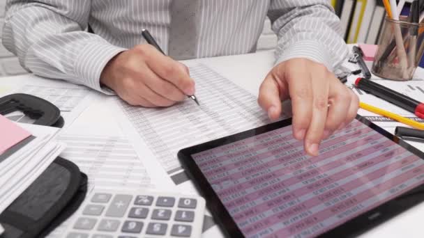 Концепция бизнес-анализа и бухгалтерского учета - бизнесмен, работающий с документами, таблицами, с помощью калькулятора, планшетного ПК. Офис крупным планом.  - Кадры, видео