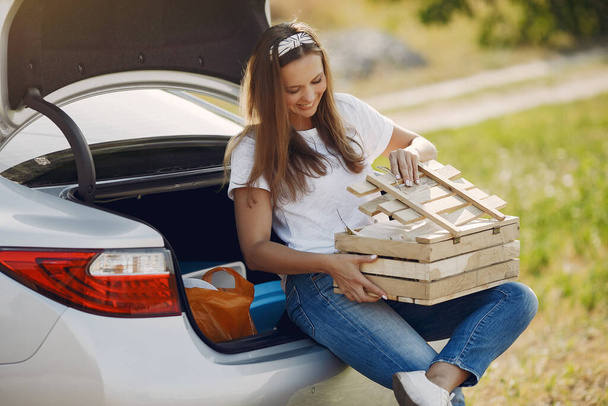 Elegant woman sitting in a trunk with wood box - Foto, imagen