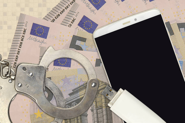 5ユーロ札と警察の手錠付きスマートフォン。ハッカーの概念フィッシング攻撃、違法詐欺やオンラインスパイウェアソフト配布 - 写真・画像