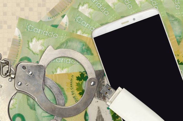 20 Canadian dollars bills and smartphone with police handcuffs. Concept of hackers phishing attacks, illegal scam or online spyware soft distribution - Photo, Image