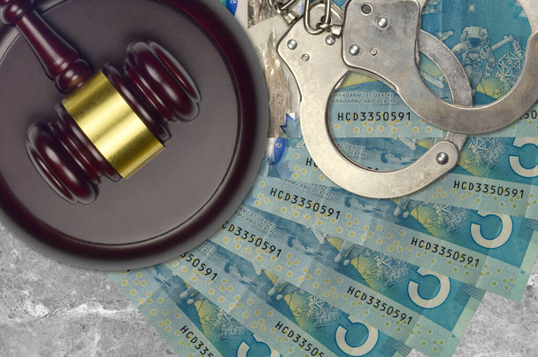 5 καναδικά χαρτονομίσματα και σφυρί δικαστή με αστυνομικές χειροπέδες στο γραφείο του δικαστηρίου. Έννοια της δικαστικής δίκης ή δωροδοκίας. Φορολογία ή φοροδιαφυγή - Φωτογραφία, εικόνα