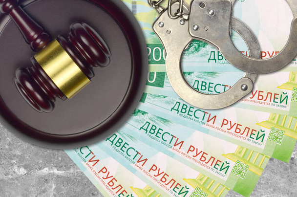 200 Rus rublesi banknot ve mahkeme masasında polis kelepçeli yargıç çekici. Yargılama ya da rüşvet kavramı. Vergi kaçırma ya da vergi kaçırma - Fotoğraf, Görsel