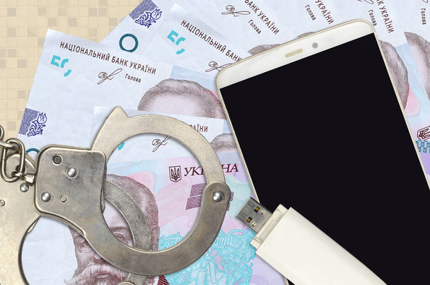 50 ukrajinských bankovek za hřivnu a smartphone s policejními pouty. Koncepce hackerů phishing útoky, nelegální podvod nebo online spyware soft distribuce - Fotografie, Obrázek