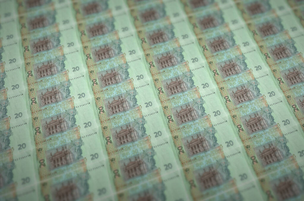 違法資金生産コンベアに印刷された20ウクライナのハイブリッド法案。多くの偽札のコラージュ。偽造者の大量労働の概念 - 写真・画像
