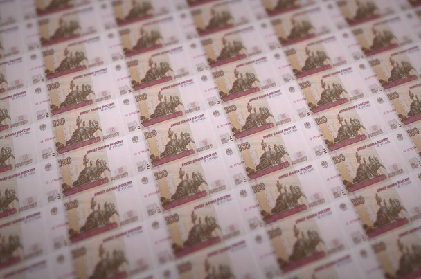100 orosz rubel bankjegy illegális pénzgyártásban. Sok hamis bankjegy kollázsa. A hamisítók tömeges munkájának fogalma - Fotó, kép