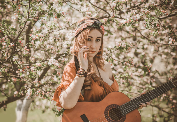 Mujer gitana con cartas de Tarot y guitarra en el campo, estilo de vida, predicción, ideas para el disfraz en Halloween
 - Foto, imagen