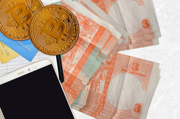 3 pesos cubains billets convertibles et bitcoins dorés avec smartphone et cartes de crédit. Concept d'investissement crypto-monnaie. Opérations minières ou commerciales cryptographiques - Photo, image