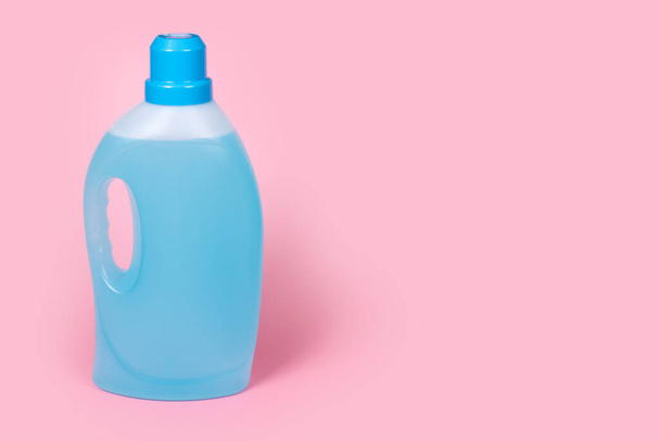 Eine Flasche Waschmittel auf rosa Hintergrund. Plastikbehälter mit Reinigungsprodukten, Haushaltschemikalien oder flüssigem Waschmittel. Wäschetag, Reinigungskonzept. Kopierraum für Text - Foto, Bild