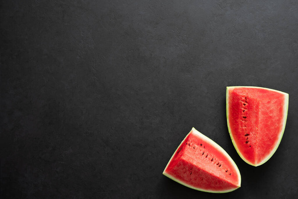 Two pieces of fresh watermelon on black background. Copy space. - Photo, Image