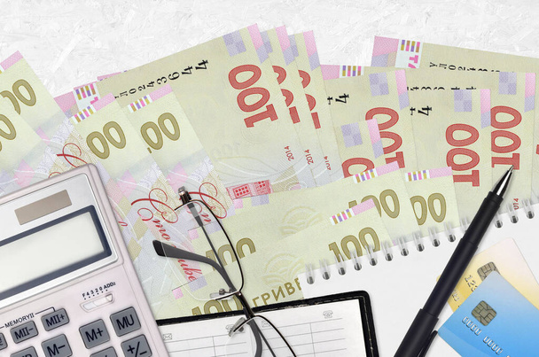 100 ukrajinských hryvnias bankovky a kalkulačka s brýlemi a perem. Daňové období koncept nebo investiční řešení. Finanční plánování nebo účetní administrativa - Fotografie, Obrázek