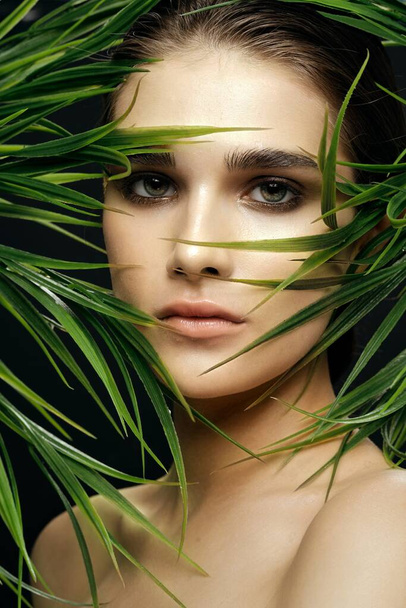 Vrouwelijke gezicht make-up natuurlijke look van de natuur groene bladeren gezondheid  - Foto, afbeelding