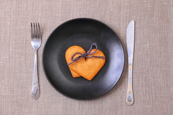 Heart shaped gingerbread cookie on the black plate - Foto, imagen