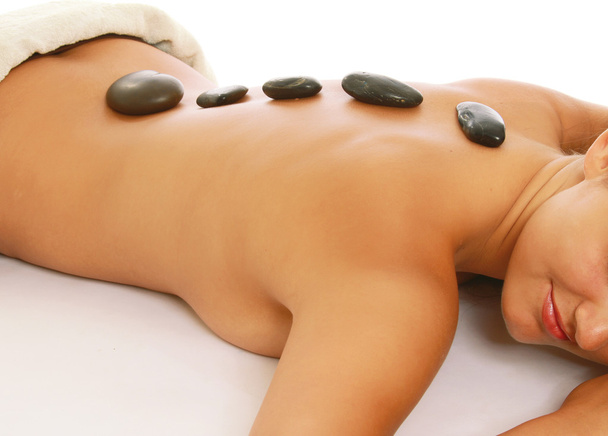 A woman getting a stone therapy in spa center - Foto, afbeelding