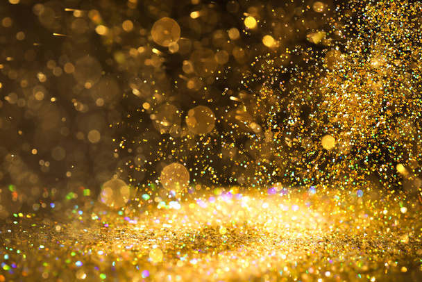 Luxury golden glitters on dark background. Bokeh effect  - Foto, afbeelding