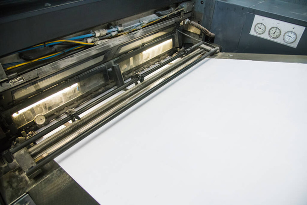 Prensas de impresión en el trabajo en la impresión. Las hojas impresas de papel se sirven en la imprenta
 - Foto, Imagen