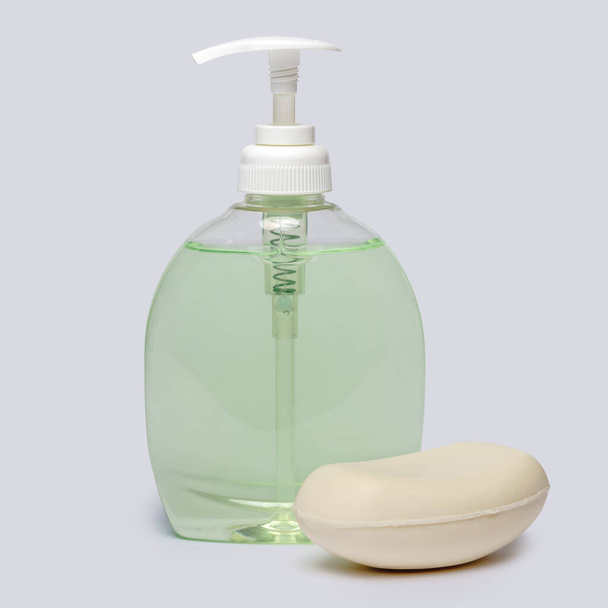 piece of soap and bottle of liquid soap over light grey backgound with clipping path - Fotografie, Obrázek
