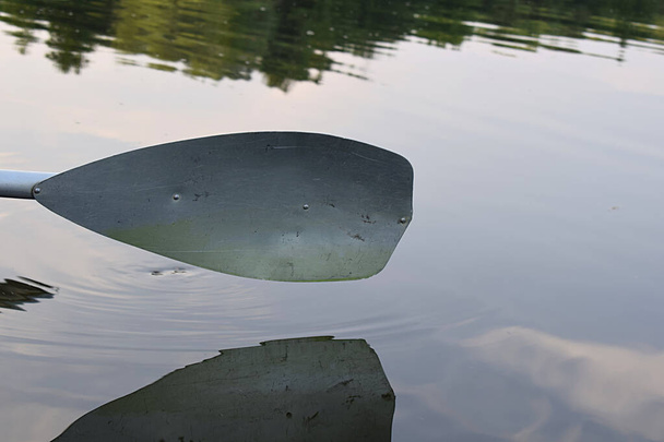 Pagaia kayak sopra l'acqua calma e il suo primo piano di riflessione. - Foto, immagini
