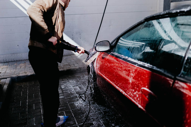 washing a red car with a compressor with water. - Photo, Image