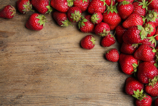 Delicious ripe strawberries on wooden table, flat lay. Space for text - Fotó, kép