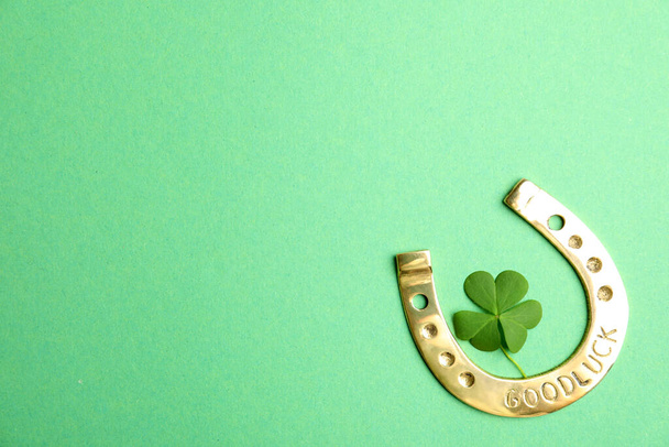 Clover leaf and horseshoe on green background, flat lay with space for text. St. Patrick's Day celebration - Foto, Imagen